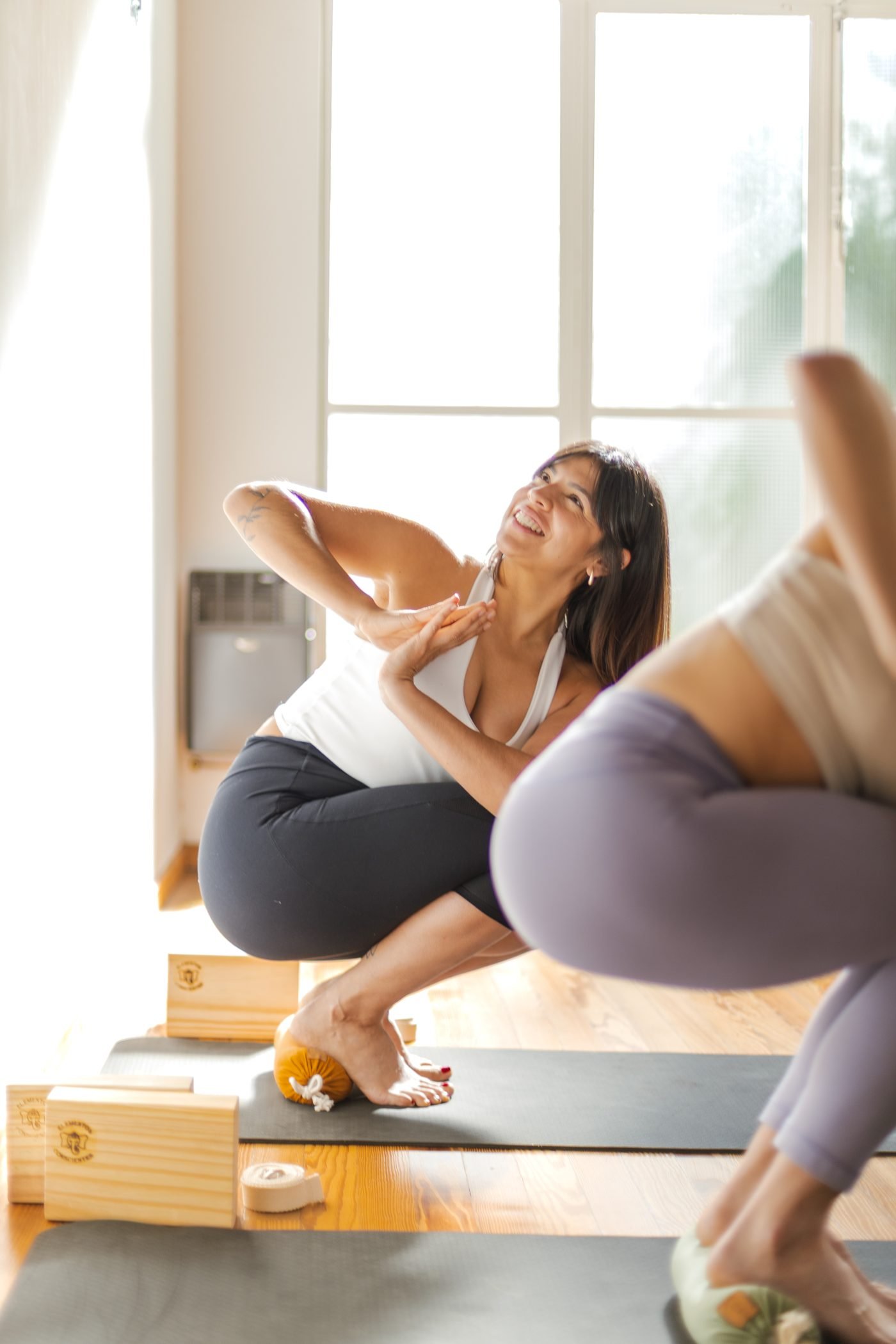 Vic sonriendo durante una clase de yoga, en un salón con luz natural